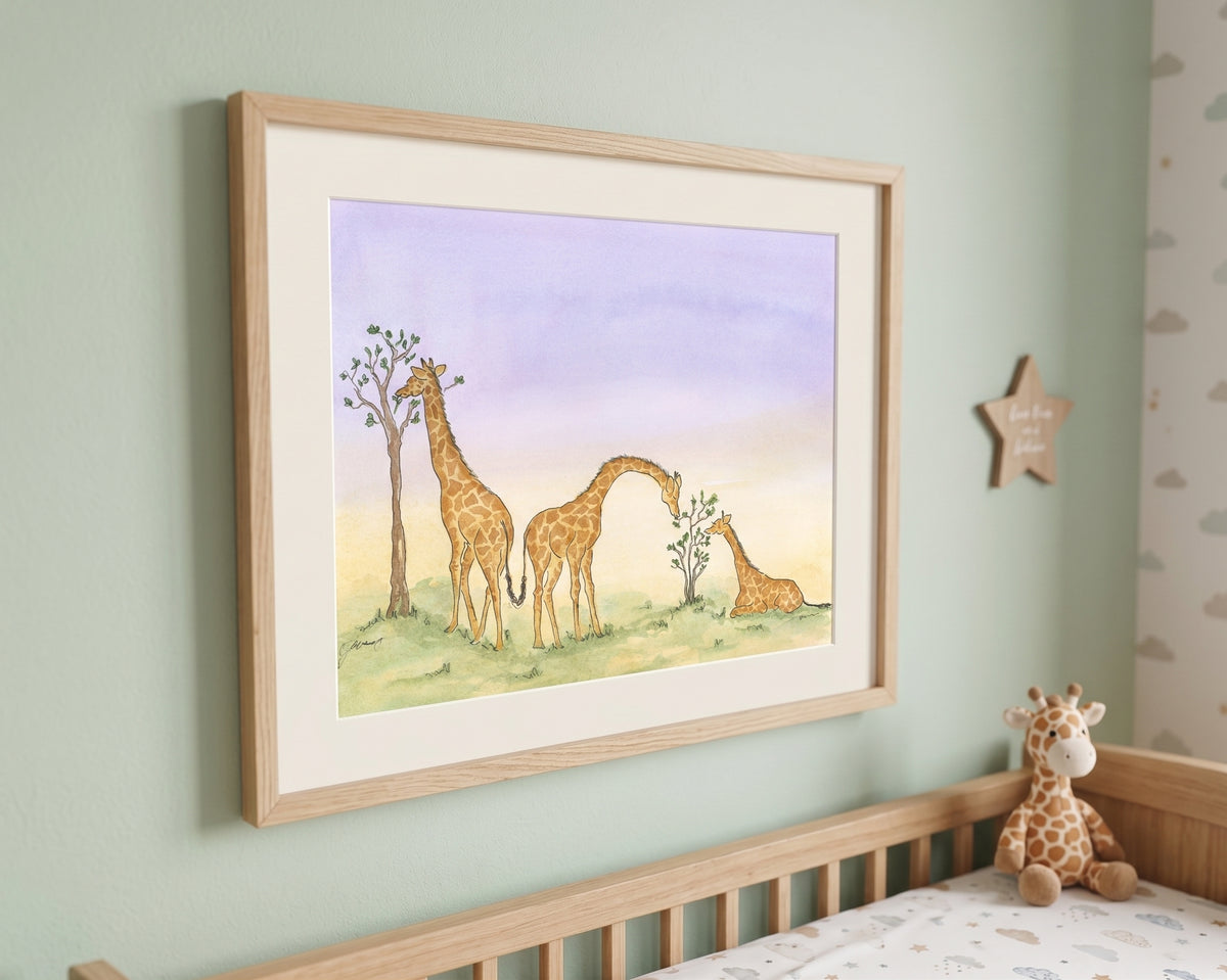 A framed watercolor art print depicting three giraffes in a savanna landscape, hung on a light green wall above a wooden crib with a stuffed giraffe toy.