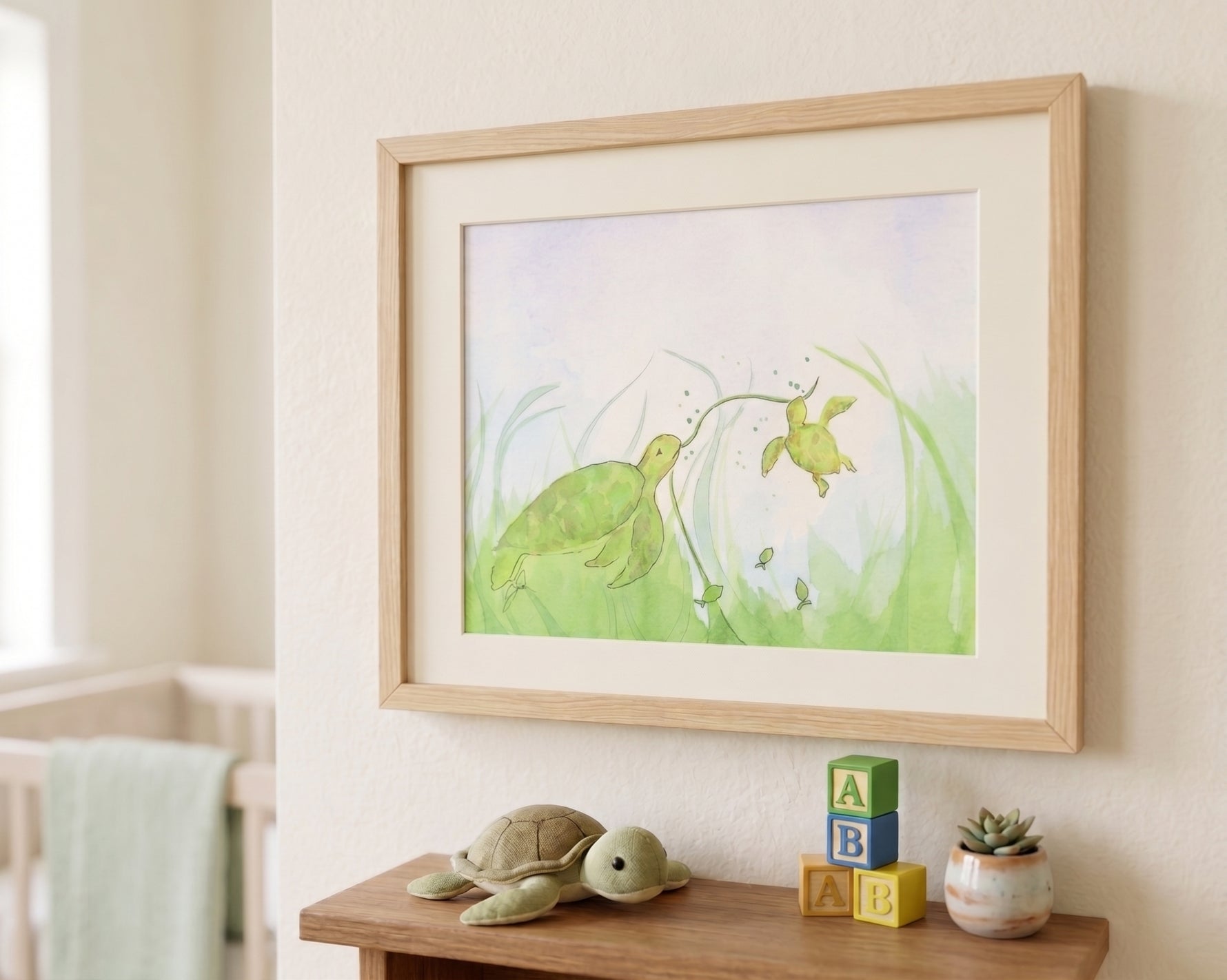 Framed sea turtle watercolor art print hanging on a neutral wall in a cozy nursery above a shelf with wooden toys.