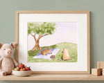 A framed watercolor art print titled "Pigs Picnic" by Judy Taussig hanging on a sage green wall above a wooden shelf, depicting two pigs on a picnic blanket under a tree with apples.
